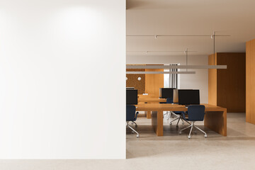 Naklejka na ściany i meble Modern office interior featuring a large blank wall for poster mockup beside an open workspace with wooden desks and minimalist design elements. 3D Rendering