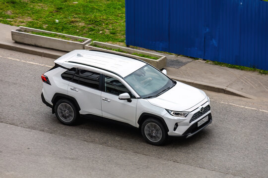 Toyota RAV4 XA50 SUV car on the city road. Fast moving white crossover on urban street. Compliance with speed limits on the road