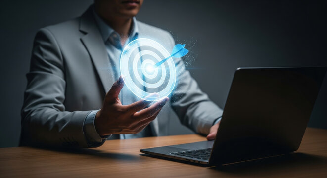 Business target achievement with technology concept Man works on laptop with target in hand aiming to hit goal Professional success strategy planning