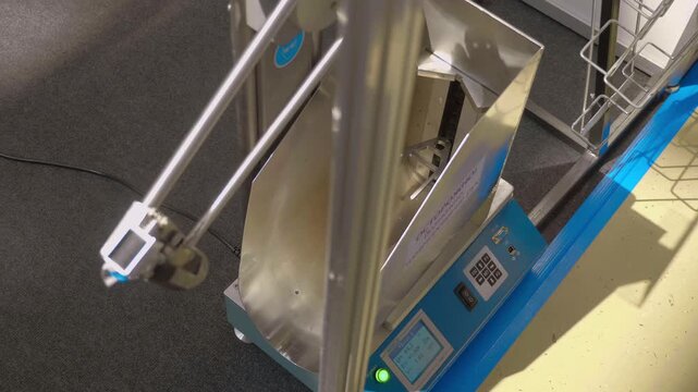 Glass bottle impact strength tester is on display at the exhibition. Closeup. Shot in motion