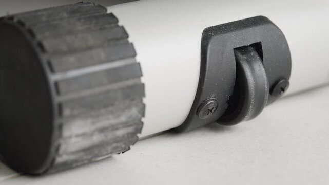 Small caster wheel providing mobility to a durable grey and black object