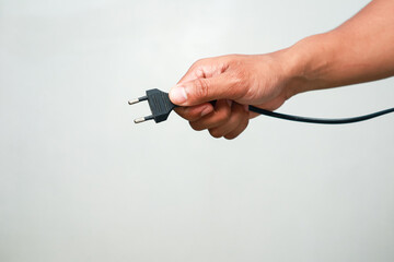 Fototapeta premium Hand holding electric plug ready to connect power source