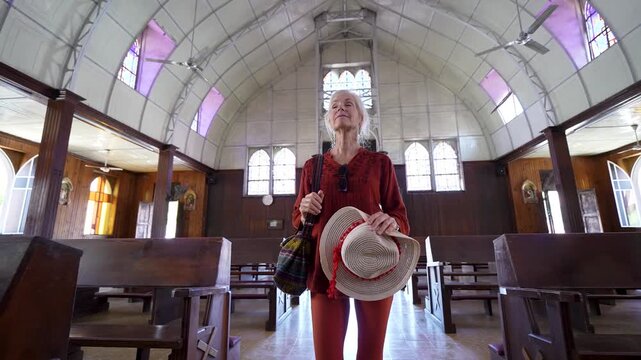 Mature woman walks through a historic church in Santa Rosalia, appreciating the architecture and local culture in Baja California, Mexico.
