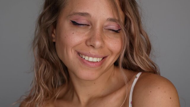 Playful young attractive blonde woman with freckles and wavy hair sticking out tongue. Fun facial expression, teasing mood, natural beauty and carefree lifestyle concept