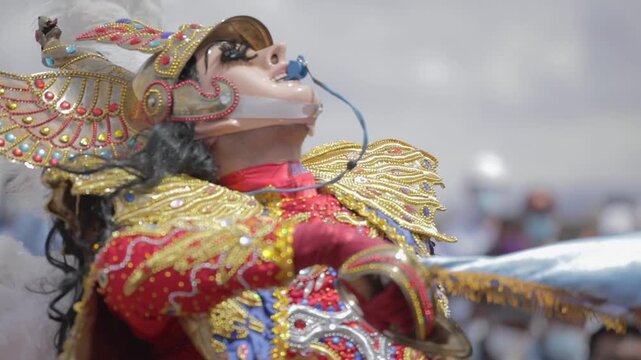 In Bolivia, an angel from the traditional Bolivian dance "Diablada" moves to the rhythm of the music. Wearing a highly elaborate costume, they feature a mask, wings, and a colorful outfit 