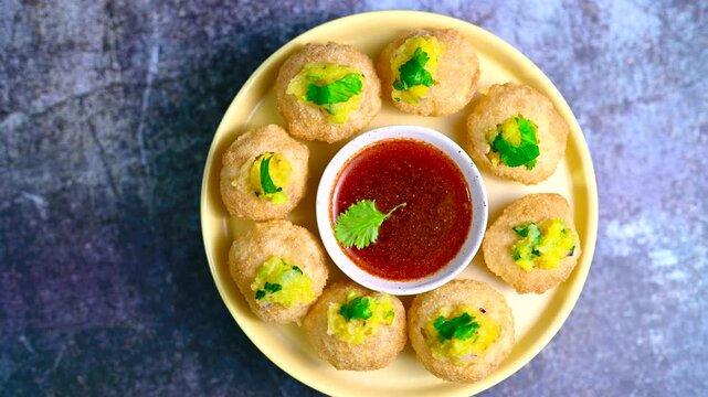 Close up of Indian street food fuchka on a plate glass with sour spicy water. Dahi Pani puri a chat item in India. 4K indian street food snacks.
