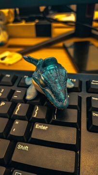 dinosaur toy on a computer keyboard