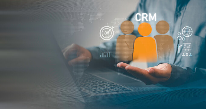 Concept of customer relationship management, data strategy, sales automation, and marketing performance optimization. Business professional holding CRM cube icon with digital analytics interface.
