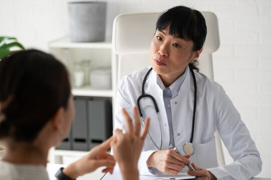 Female physician talking with patient during healthcare consultation in modern office. Medical advice, emotional support and preventive care concept.
