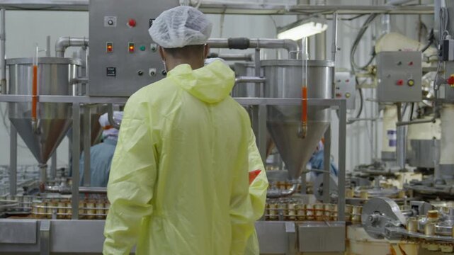 Food factory automated production line, industrial factory protective suit masked worker safety glove quality control food processing plant, sterile production line inspection, stainless steel