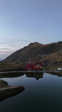 Balea Lake Chalet reflection at dusk in Carpathian Mountains Romania