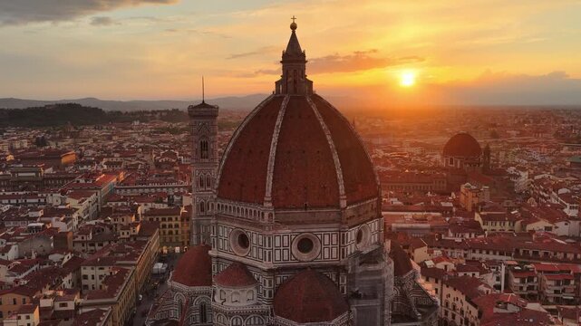 flying around Florence cathedral dome at sunset, scenic drone shot of Santa Maria del Fiore cathedral with the setting sun, travel in Italy