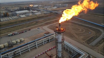 Fire on flare stack at refinery oil and gas central processing platform while burning toxic and release over pressure. gas flare at an oil refinery factory industrial. Aerial view. © pinan
