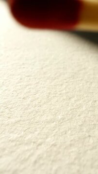 Close up of match head and flame ready on textured surface