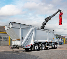 Waste management. Waste truck with crane for lifting an underground garbage container. Garbage transport truck with crane © A