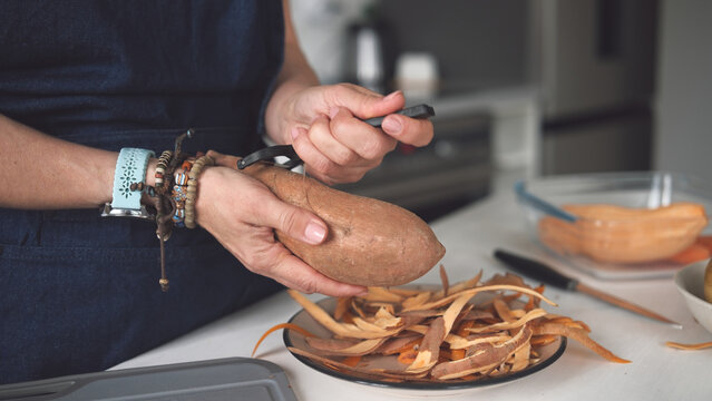 Woman Cleaning Raw Sweet Potato