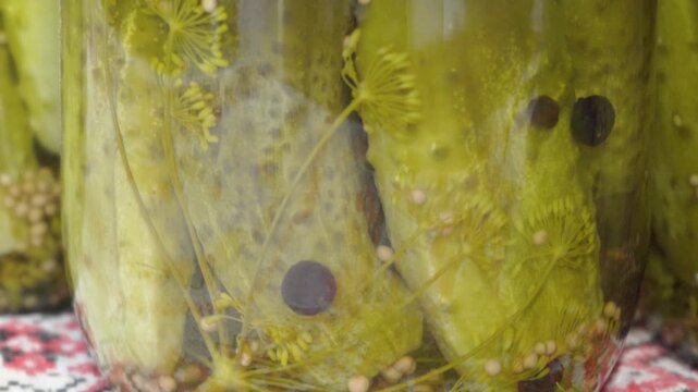 Close up of pickled cucumbers in glass jar with dill and spices, Homemade marinated gherkins with mustard seeds and black pepper