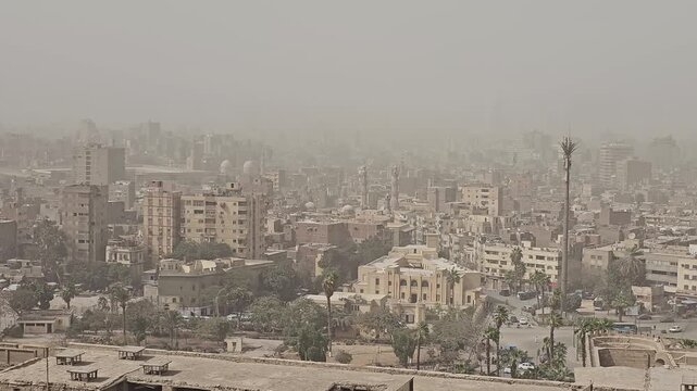 Dusty atmospheric skyline of Cairo, Egypt, dominated by the medieval Sultan Hassan and Al-Rifa'i mosque complex, featuring tall minarets, stone domes and ornate facades.