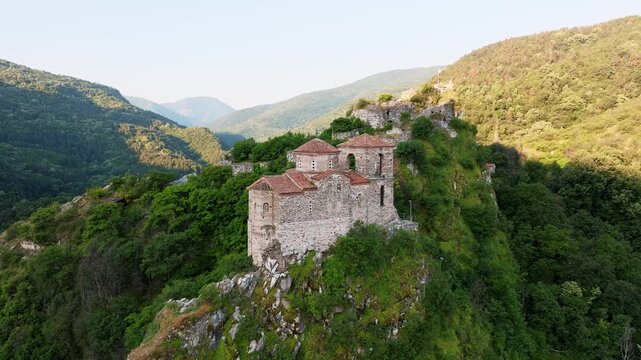 Medieval Asen Fortress Bulgaria Drone High Angle Stone Church Rocky Hill Dense Green Forest Rhodope Mountains Golden Light Heritage Travel Tourism History Landmark Adventure Concept Video
(202 символо