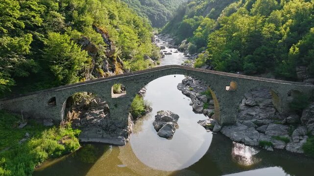 Bulgaria Rhodope Devil Bridge Drone High Angle Stone Arch Medieval Arda River Rocky Gorge Dense Green Forest Summer Heritage Travel Tourism History Architecture Landmark Concept Video