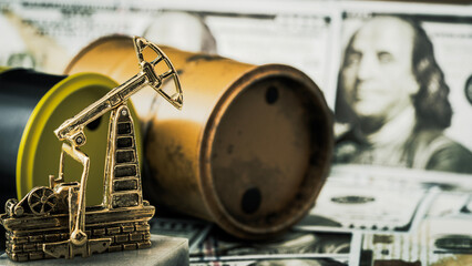 Oil pump stands beside barrels on dollar bills © I