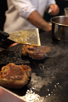cocinero friendo carne de cerdo a la parrilla usando una paleta de cocina