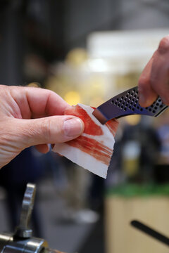 cortador profesional de jam&oacute;n ib&eacute;rico entregando una loncha de jam&oacute;n a un comensal