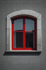 Obraz premium Portrait of red window on gray wall background 