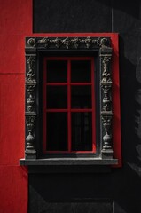 Obraz premium Portrait of red window on black wall background 