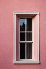 Fototapeta premium Portrait of black window on pink wall background 