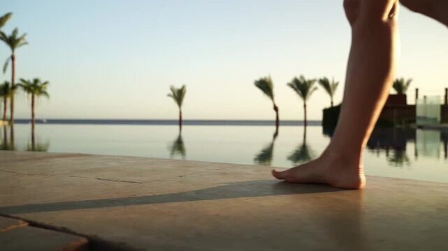 Sunlight glows softly over the poolside. Feet step gently along the warm stone edge. Reflections ripple with calm, quiet waters. Silhouettes sway against palm trees' gentle sway