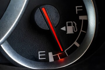 Naklejka premium Low fuel gauge on car dashboard, close-up.