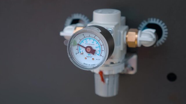 A pressure gauge with an adjustable control mark for industrial equipment, which allows you not to exceed the specified values. Closeup. Shot in motion