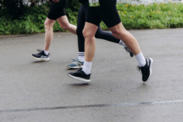 Fototapeta premium Marathon runners crowd, sportsmen participants start running the half-marathon in the city streets, crowd of sportswomen joggers in motion, group of athletes outdoor training competition in summer day