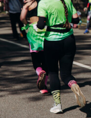 Fototapeta premium Marathon runners crowd, sportsmen participants start running the half-marathon in the city streets, crowd of sportswomen joggers in motion, group of athletes outdoor training competition in summer day