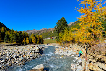 Blick über den steinigen Karlinbach auf den Weiler Melag im herbstlichen Langtauferer Tal, Südtirol © Ilhan Balta