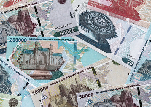 Uzbekistani som money banknotes pile on table. Uzbekistan bills of UZS currency close up