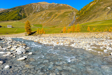 Blick über den steinigen Karlinbach auf den Weiler Melag im herbstlichen Langtauferer Tal, Südtirol © Ilhan Balta