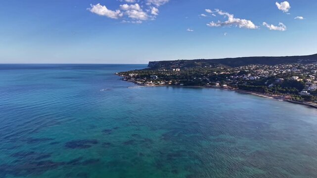 Aerial turquoise bay coastline clear water shimmering under sun drone survey captures coral patches