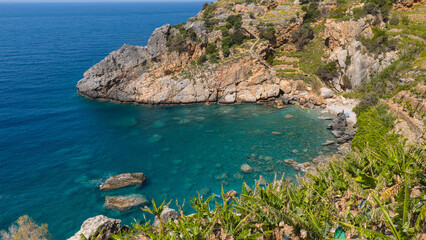 Obraz premium A hidden, rocky, turquoise-colored paradise cove nestled behind banana trees in Gazipaşa.