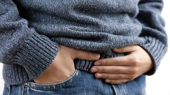 Person Holding Stomach Due to Flatulence in Casual Setting While Standing