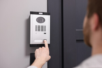 Naklejka premium Man pressing button on intercom panel indoors, closeup