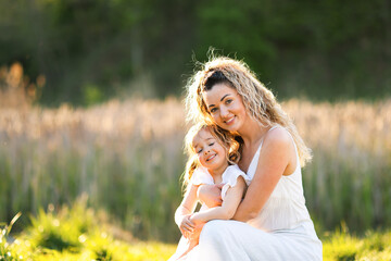 Obraz premium Mother with her cute little daughter in nature on sunny day. Space for text