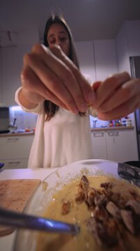 Overhead view captures baker adding nuts to mixture meticulously