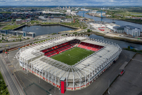 Middlesbrough Town Football Club Riverside Stadium beside the River Tees, looking towards the Transporter Bridge and city skyline.