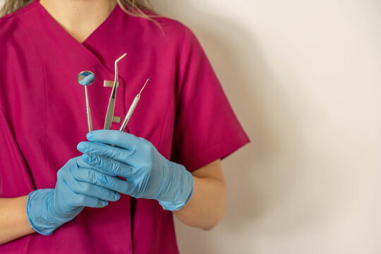 Dentist hands holding dental tools wearing blue gloves