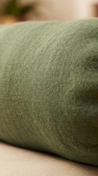 Close up of green upholstered cushion in soft indoor light