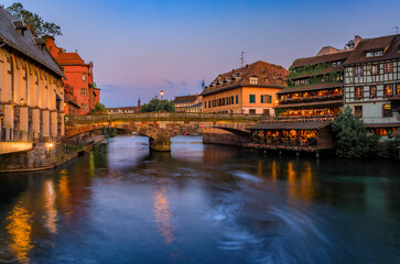Naklejka premium Half timbered houses by canals of Petite France in Strasbourg, France at sunset