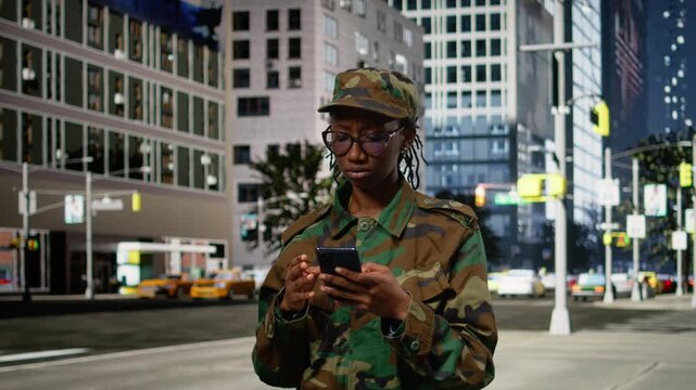 Black military soldier devastated after reading bad news on her phone, sad and depressed woman worried about future mission and global conflict. Army officer crying on city street downtown.