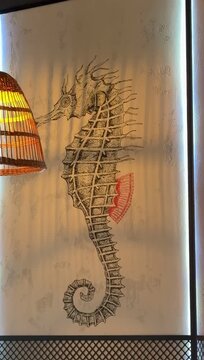 Seahorse dragon mural on wall warm wicker lamp glow, delicate linework with red fin accent, textured plaster background, metal